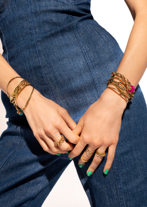 Mains avec bracelets dorés et argentés sur tenue en jeans bijoux MYA BAY